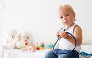 A toddler holds a stethoscope